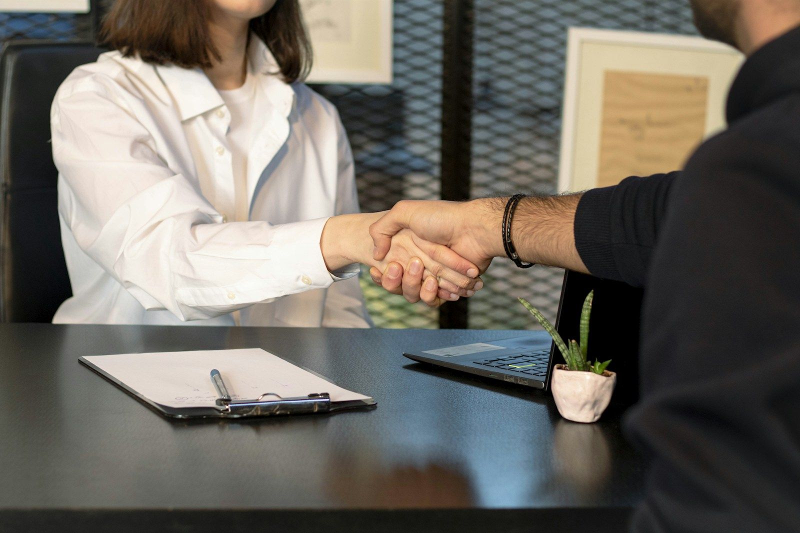 Stretta di mano davanti a un laptop durante una consulenza